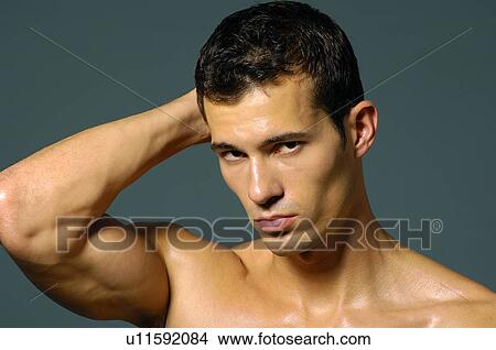 Portrait of a young man flexing his biceps View Large Photo Image Picture - Portrait of a young man flexing his biceps. Fotosearch