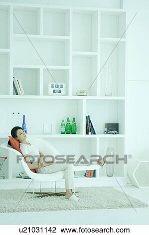 A young woman relaxing in chair View Large Photo Image Stock Image - A young woman relaxing in chair. Fotosearch