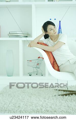 Stock Photo - A young woman relaxing in chair. Fotosearch