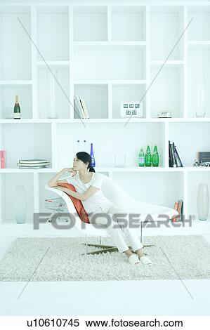 A young woman sitting in chair View Large Photo Image Stock Photography - A young woman sitting in chair. Fotosearch