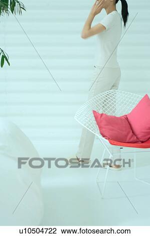 A young woman walking in living room View Large Photo Image Stock Image - A young woman walking in living room. Fotosearch