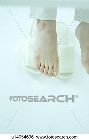 Stock Photograph - A young woman's feet under table. Fotosearch