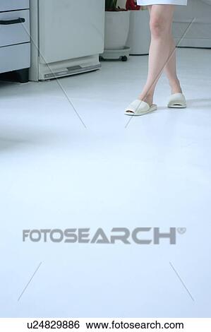 Stock Photograph - A young woman's legs in kitchen. Fotosearch