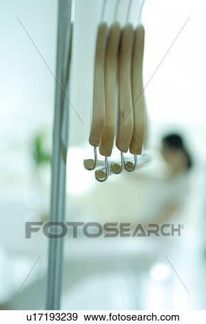 Hangers with a young woman in the background View Large Photo Image Stock Photo - Hangers with a young woman in the background. Fotosearch