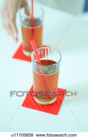 Two glasses of Ice Tea with a hand View Large Photo Image Stock Photo - Two glasses of Ice Tea with a hand. Fotosearch