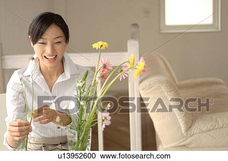 Stock Image - A young woman arranging flower. Fotosearch