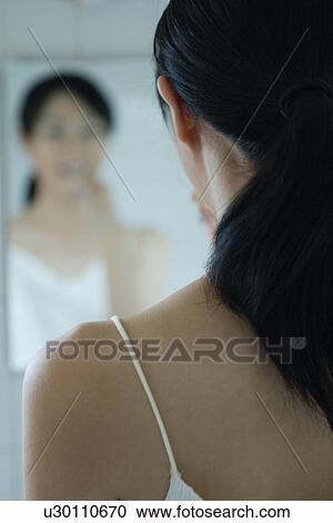 A young woman brushing teeth, rear view View Large Photo Image Stock Image - A young woman brushing teeth, rear view. Fotosearch