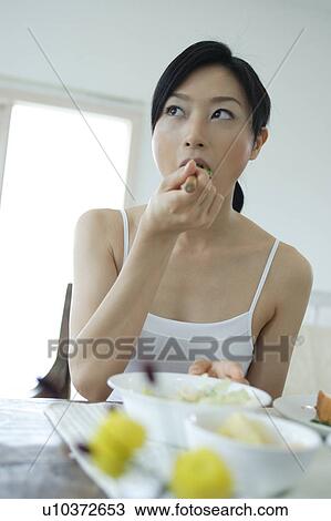 A young woman eating breakfast View Large Photo Image Stock Image - A young woman eating breakfast. Fotosearch