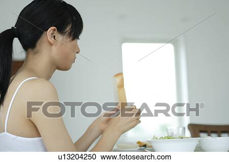 A young woman eating breakfast View Large Photo Image Stock Image - A young woman eating breakfast. Fotosearch