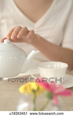 A young woman holding a teapot View Large Photo Image Stock Image - A young woman holding a teapot. Fotosearch