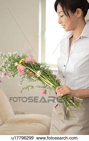 Stock Photo - A young woman holding flower. Fotosearch