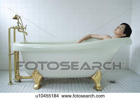 Picture - A young woman in bathtub, side view. Fotosearch