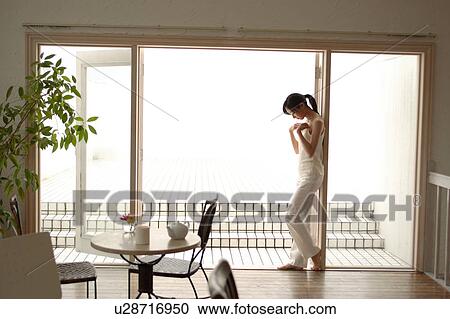 A young woman looking down in living room View Large Photo Image Stock Image - A young woman looking down in living room. Fotosearch