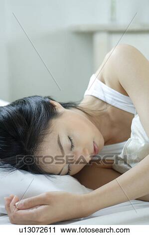 A young woman sleeping in bed, close-up View Large Photo Image Stock Image - A young woman sleeping in bed, close-up. Fotosearch