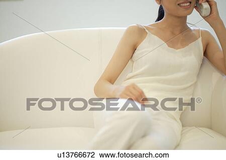 Stock Image - A young woman talking over phone. Fotosearch