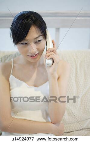 A young woman talking over phone View Large Photo Image Stock Photo - A young woman talking over phone. Fotosearch