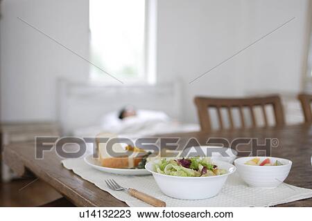 Breakfast at table with a woman sleeping in the background View Large Photo Image Stock Image - Breakfast at table with a woman sleeping in the background. Fotosearch