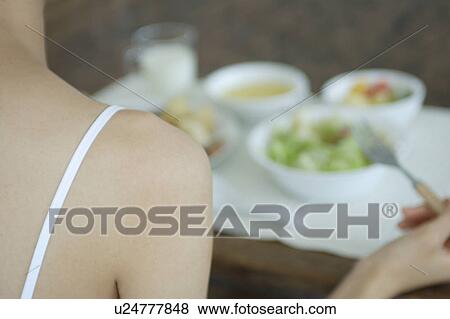 Close-up of a young woman eating breakfast, rear view View Large Photo Image Stock Photo - Close-up of a young woman eating breakfast, rear view. Fotosearch