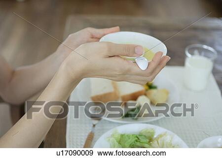Stock Photo - Close-up of a young woman holding soup bowl. Fotosearch
