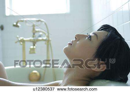 Close-up of a young woman in bathtub View Large Photo Image Stock Photo - Close-up of a young woman in bathtub. Fotosearch