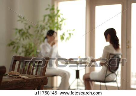 Comb with two young women drinking tea in the background View Large Photo Image Stock Photography - Comb with two young women drinking tea in the background. Fotosearch