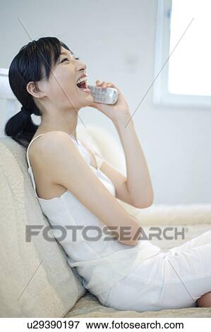 Stock Photo - Laughing young woman talking over phone. Fotosearch