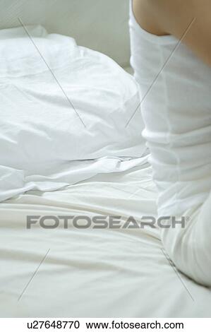 Midsection of a young woman in bed View Large Photo Image Stock Image - Midsection of a young woman in bed. Fotosearch