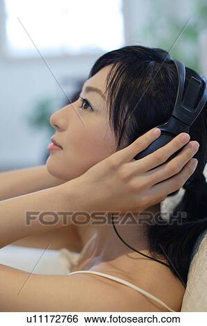 Profile of a young woman listening to music View Large Photo Image Stock Photograph - Profile of a young woman listening to music. Fotosearch