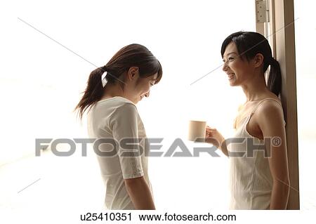 Two young women talking View Large Photo Image Stock Image - Two young women talking. Fotosearch