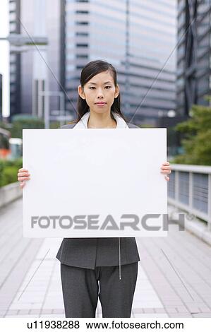 A young business woman holding blank message View Large Photo Image Stock Photo - A young business woman holding blank message. Fotosearch