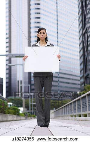 A young business woman holding blank message View Large Photo Image Stock Photograph - A young business woman holding blank message. Fotosearch