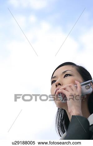 A young business woman talking over mobile phone View Large Photo Image Stock Photography - A young business woman talking over mobile phone. Fotosearch