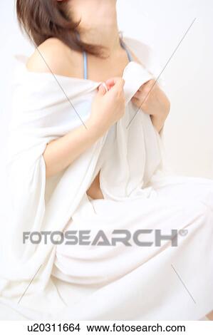 Picture - A young woman covering with white sheet. Fotosearch