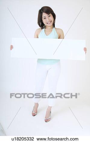 Stock Image - Portrait of a young woman holding blank message. Fotosearch