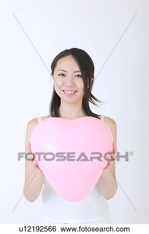 Stock Photograph - Portrait of a young woman holding balloon. Fotosearch