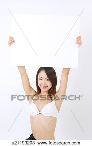Portrait of a young woman in bikini holding blank message View Large Photo Image Stock Image - Portrait of a young woman in bikini holding blank message. Fotosearch