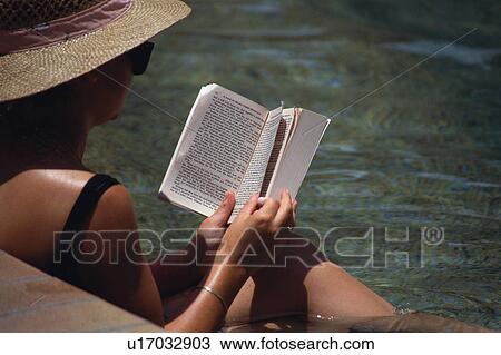 Adult woman reading book at poolside View Large Photo Image Stock Image - Adult woman reading book at poolside. Fotosearch