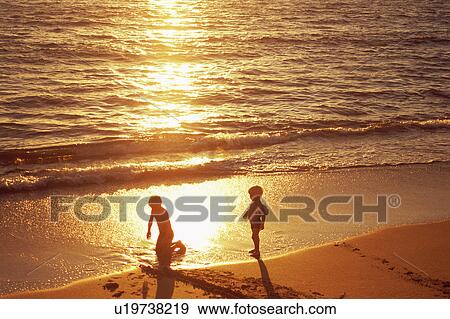 Boys playing at beach in sunset View Large Photo Image Stock Photo - Boys playing at beach in sunset. Fotosearch