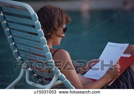 Mid adult woman writing letter at pool side View Large Photo Image Stock Image - Mid adult woman writing letter at pool side. Fotosearch