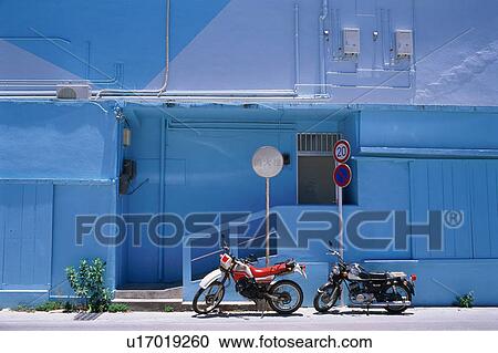 Stock Image - Motor bicycle and blue building. Fotosearch