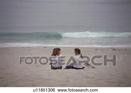 Two young girl talking at beach View Large Photo Image Stock Photograph - Two young girl talking at beach. Fotosearch