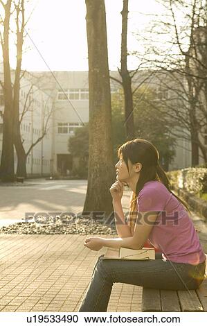 College student sitting on bench View Large Photo Image Stock Image - College student sitting on bench. Fotosearch