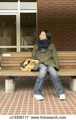 College student sitting on bench View Large Photo Image Stock Photo - College student sitting on bench. Fotosearch