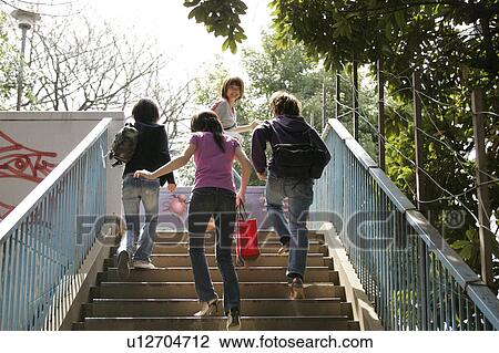 Four college students walking up stairs View Large Photo Image Stock Image - Four college students walking up stairs. Fotosearch