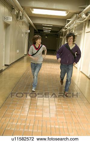 Two college students running down corridor View Large Photo Image Stock Image - Two college students running down corridor. Fotosearch