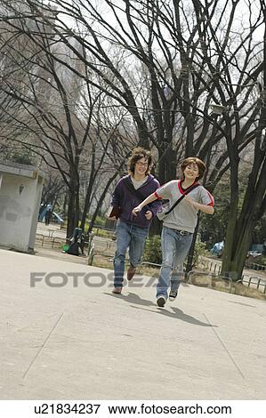 Two college students running View Large Photo Image Stock Photo - Two college students running. Fotosearch