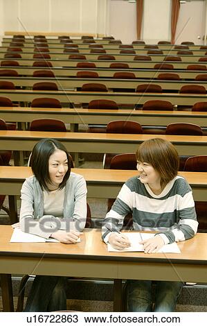 Two college students studying and talking in lecture hall View Large Photo Image Stock Image - Two college students studying and talking in lecture hall. Fotosearch