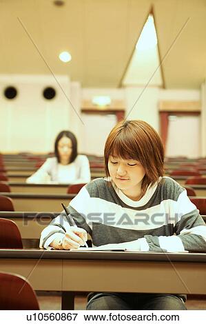Stock Photo - Two college students studying in lecture hall. Fotosearch