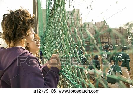 Two college students watching baseball game View Large Photo Image Stock Photograph - Two college students watching baseball game. Fotosearch