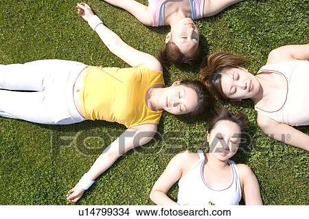 Four young women lying on field View Large Photo Image Picture - Four young women lying on field. Fotosearch